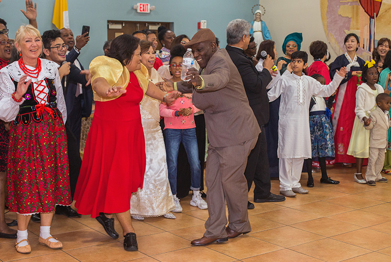 JANUARY 5, 2020
MARLENE QUARONI | FC
Alex Antoine, Haitian-American, dances with a Chinese counterpart while members of the various cultural groups in the archdiocese sing "We Are The World" at the reception that followed the annual Migration Mass, celebrated by Archbishop Thomas Wenski Jan. 5, 2020 at St. Mary Cathedral.