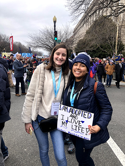 Izzy Rennella, right, poses with her homemade sign and Andrea Isla-Canedo, a fellow pilgrim from her alma mater, Immaculata-La Salle High School in Miami, during the March for Life, Jan. 24, 2020.