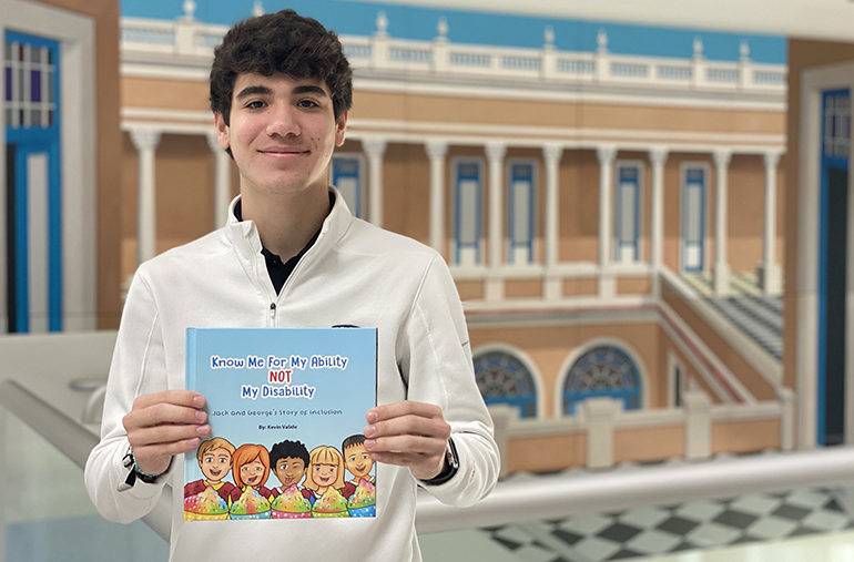 Kevin Valido, estudiante de último año en la Escuela Jesuita de Belén, muestra un ejemplar del libro que escribió para los niños: “Know Me For My Ability Not My Disability” (“Conóceme por mi capacidad, no por mi discapacidad”), que trata sobre el tema de la inclusión.