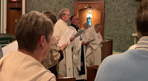 Msgr. William Dever, center, pastor of St. Paul the Apostle in Lighthouse Point, prays alongside religious leaders from other faith communities during the ecumenical service hosted by the parish, Jan. 23, 2020.