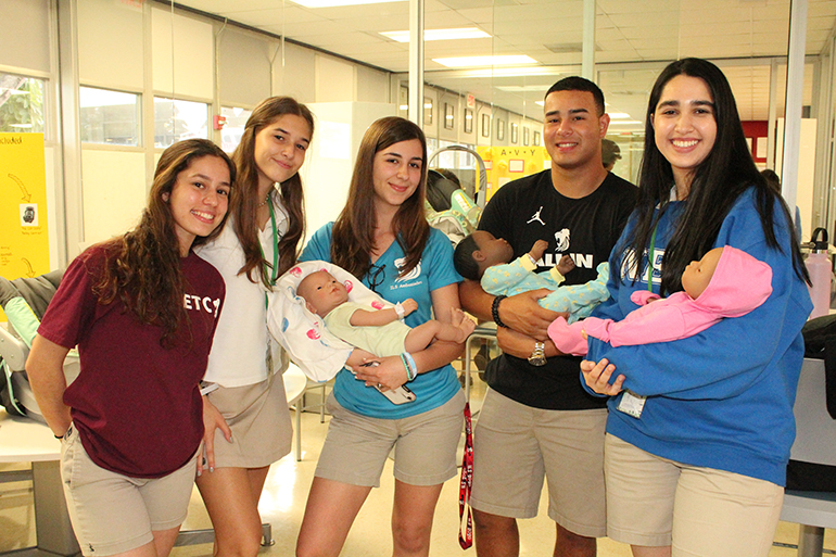 Oh babies: Immaculata-La Salle students Larissa Pontes, Camyle Pliopa, Maryrose George, Yaniel Rodriguez, and Gianella Martinez Gugliotta pose with some of the practice baby dolls given to students in the Health Science focus program.