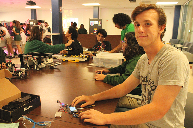 Nicholas Blanco, estudiante de ingeniería y robótica de Immaculata-La Salle, retoca una consola de videojuegos portátil Gameboy que construyó y trajo para exhibir en la celebración del Día Nacional de STEAM en la escuela, que tuvo lugar en noviembre.