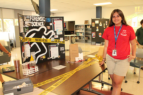 Who done it? Immaculata-La Salle senior Danielle Ladron de Guevara poses by the makeshift crime scene that students built for the STEAM Day celebration exhibit in November. Danielle wants to pursue medicine, but after taking a class in forensics, she is considering pursuing a career in the field.