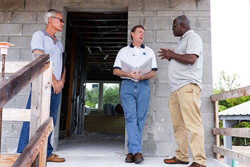 Jules Jones, right, CFO of Catholic Charities of the Archdiocese of Miami, makes a point during a walkthrough tour in Key West for a new Catholic Charities-sponsored St. Bede’s Village workforce development facility in Key West, expected to be completed sometime in the summer of 2020.  With him are Key West-based architect William Horn, left, and Mark Shaughnessy, center, owner's representative for the building project.