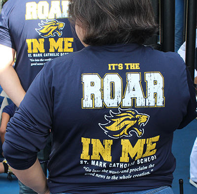 Teachers and faculty members wear "It's the Roar In Me" T-shirts during a pep rally celebrating St. Mark School's 25th anniversary on Jan. 24, 2020.
