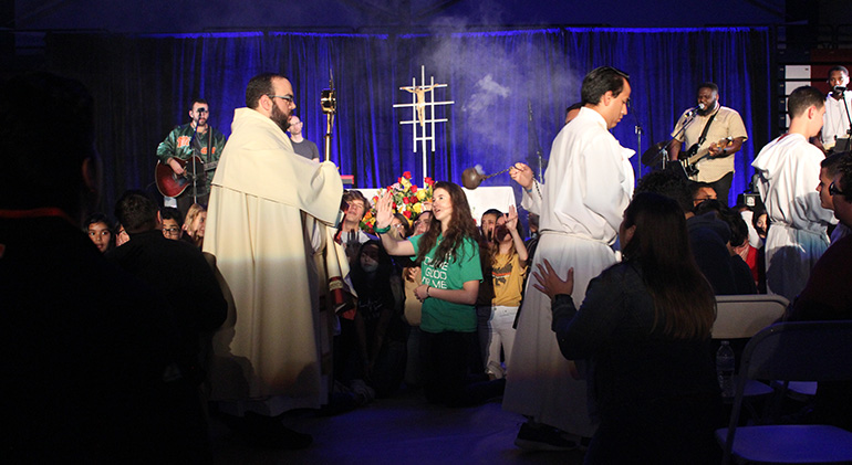 Father Matthew Gomez, parochial vicar at St. John Neumann Parish in Miami, leads the eucharistic procession and adoration that concluded this year's Mercy Night, held in the Fernandez Family Center of St. Thomas University, Jan. 31, 2020. Mercy Night attendees included teens, young adults and families.