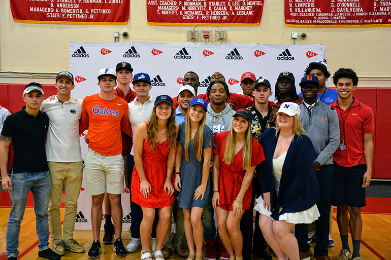 Nineteen of the 20 Cardinal Gibbons students who have signed National Letters of Intent to play their sports at the college level pose for a photo after the signing ceremony Feb. 5, 2020.
