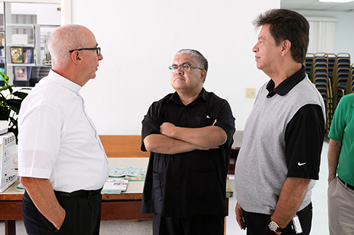 El P. Luis Alberto Pérez (a la izquierda), párroco de San Pablo en Marathon, habla Mons. Roberto Garza, (al centro), presidente de la junta de Caridades Católicas de la Arquidiócesis de Miami, y Peter Routsis-Arroyo, director de Caridades Católicas, durante el recorrido reciente de estos dos últimos por las parroquias y programas en el condado Monroe.