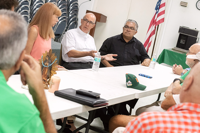 El P. Luis Alberto Pérez (al centro), habla con los miembros de la delegación de la junta de directores de Caridades Católicas de la arquidiócesis de Miami, durante su recorrido reciente por parroquias y programas en el condado Monroe. A la derecha, Mons. Roberto Garza, presidente de la junta de Caridades Católicas.