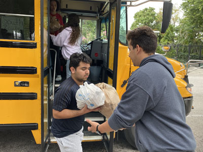 Msgr. Edward Pace High students fill a school bus with bagged meals they prepared for the homeless during Hungerfest, a pre-Lenten retreat where students, faculty and volunteers combine their own fasting with prayers, meal prepping and packing.