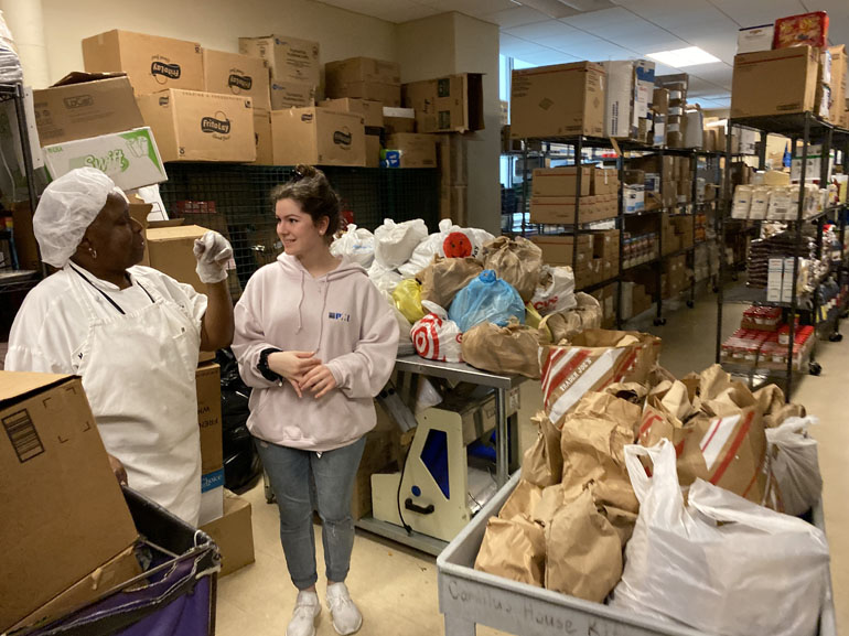 Helping the pantry that feeds: At the Camillus House pantry, a Hungerfest participant from Msgr. Edward Pace High listens to an employee. As part of their annual pre-Lenten retreat, Pace students delivered meals they prepared and packed.