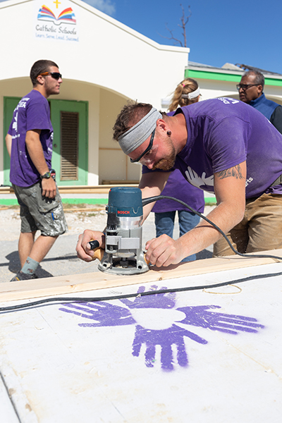 International volunteers make preliminary repairs at St. Francis de Sales School in Abaco, which was closed following last year's devastating Category 5 Hurricane Dorian.