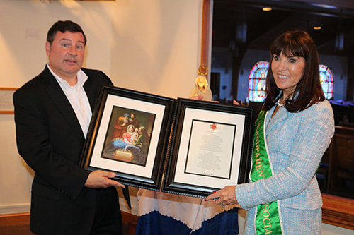 Stephen Colella, cabinet secretary of Parish Life in the Archdiocese of Miami, holds a picture of the Holy Family and a framed prayer for grandparents with Catherine Wiley, founder of the Catholic Grandparents Association. She was asked to speak at an informational session for a new grandparents ministry being launched by the archdiocese.