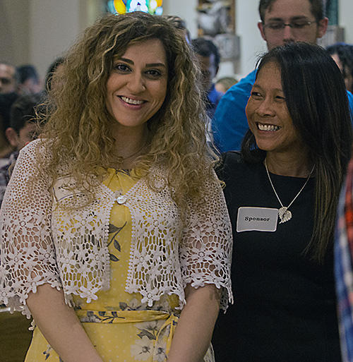 Neda Kalhor, 32, left, a catechumen from St. Bonaventure Church in Davie, stands with her sponsor, Tina McMahon, before signing the Book of the Elect at one of the two Rite of Election ceremonies held March 1, 2020, at St. Mary Cathedral.