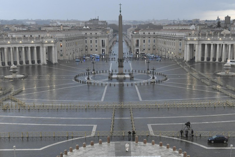 Pope Francis walks in the rain in an empty plaza outside St. Peter's Basilica March 27, 2020, before giving an Urbi et Orbi blessing and leading a prayer service for the end of the coronavirus pandemic.