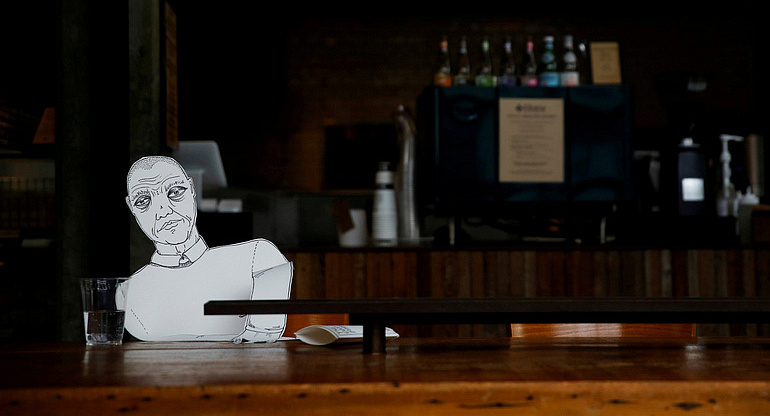 A paper cutout of a person sits at an empty table at a bagel cafe during the coronavirus pandemic in Seattle March 27, 2020. Outreach efforts by Catholic agencies continue in large part during the virus-mandated restrictions. (CNS photo/Lindsey Wasson, Reuters) See SERVICE-WORKAROUNDS March 31, 2020.