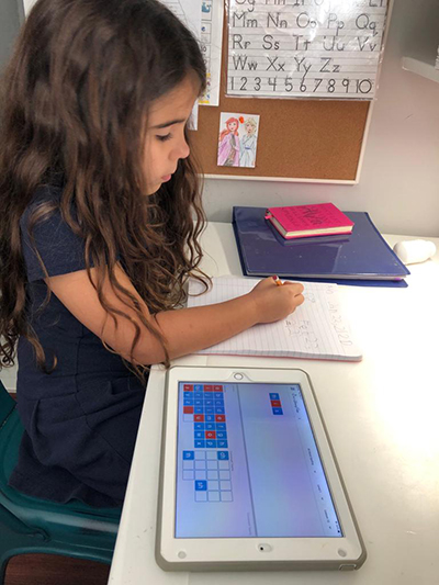 Ava Piñero, 7, works on her spelling assignment at her home desk.