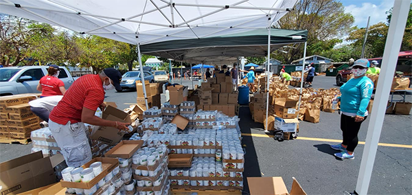 Volunteers distribute food and other essential items in front of the Rose Renna Activity Center at the Basilica of St. Mary Star of the Sea in Key West, April 21, 2020. The distribution was made possible by a coalition of agencies working together in the Keys, including the basilica-affiliated SOS Foundation on Stock Island, Catholic Charities of the Archdiocese of Miami, United Way, Ocean Reef Foundation and Farm Share.