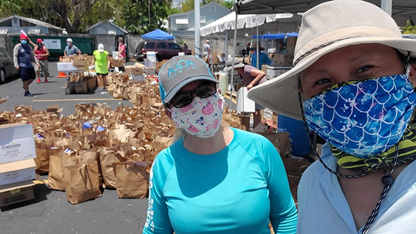 Volunteers take a selfie near the bags of food and other essential items they were distributing in front of the Basilica of St. Mary Star of the Sea's Rose Renna Activity Center in Key West, April 21, 2020. The distribution was made possible by a coalition of agencies working together in the Keys, including the basilica-affiliated SOS Foundation on Stock Island, Catholic Charities of the Archdiocese of Miami, United Way, Ocean Reef Foundation and Farm Share. See related story: https://bit.ly/2S52K16