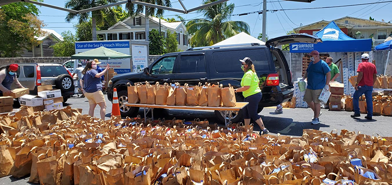 Volunteers distribute food and other essential items in front of the Rose Renna Activity Center at the Basilica of St. Mary Star of the Sea in Key West, April 21, 2020. The distribution was made possible by a coalition of agencies working together in the Keys, including the basilica-affiliated SOS Foundation on Stock Island, Catholic Charities of the Archdiocese of Miami, United Way, Ocean Reef Foundation and Farm Share.