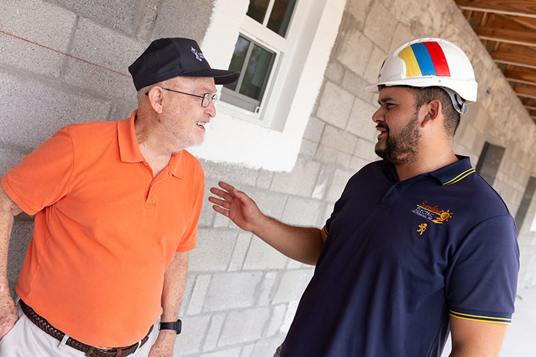 Tom Comerford, miembro del concejo de Caridades Católicas de Miami, habla con un miembro del equipo de construcción y diseño de la futura St. Bede's Village, un proyecto de Caridades Católicas para hacerle frente al problema de viviendas asequibles, en la parte baja de los Cayos de la Florida.
