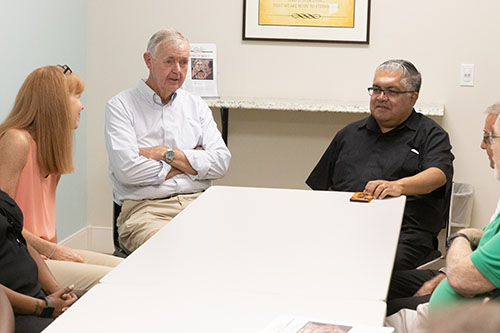 Deacon Peter Batty, left, of the Basilica of St. Mary Star of the Sea in Key West, speaks about the community needs on the island with a delegation of board members from Catholic Charities during their tour of the region late last year. At far left is Patrice Schwermer, the Key West-based Catholic Charities outreach coordinator, and at right is Msgr. Roberto Garza, president of the Miami Catholic Charities board of directors.