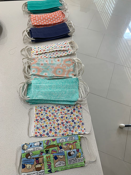 They come in navy, teal, and even Snoopy and stars: Protective masks made by St. Mark School third grader Valentina Torres and her mom Ana Carolina Abreo are laid out and organized in their homes before being distributed to healthcare providers working in hospitals during the COVID-19 pandemic.