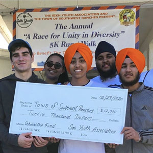 Various youth from the town of Southwest Ranches hold up the check they helped fundraise during the second annual "A Race for Unity in Diversity" 5K Run/Walk on February 29. Left to right is Nikolas Garcia, Muskan Singh, Pavitpaul Singh, Ramanpreet Singh, and Parneet Singh.
The race brings together people of all ages, races, faiths, and cultures to raise money for college scholarships for youth from the town of Southwest Ranches.