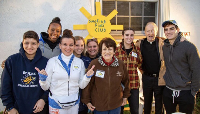 Members of the Sunshine Kids Club from Southwest Ranches pose for a photo, along with Father Patrick O'Neil archdiocesan director of Ecumenical and Interfaith Relations, who came out to support the effort.