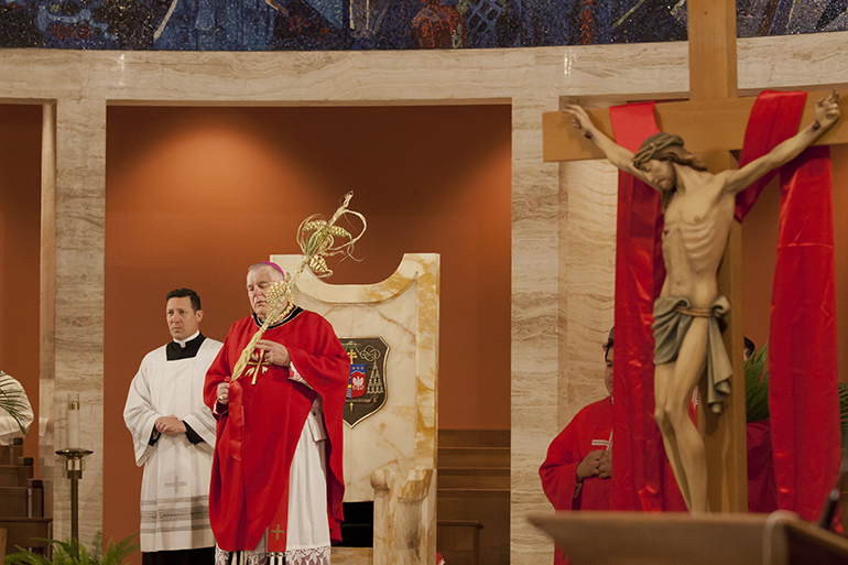 Archbishop Thomas Wenski stands in front of the cathedra during the reading of the Passion at the Palm Sunday Mass at St. Mary Cathedral in 2017.