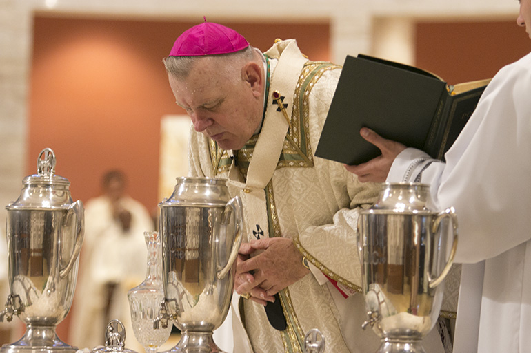 Archbishop Thomas Wenski breathes on the oil of chrism, consecrating it for use in baptisms, confirmations and ordinations. Due to the coronavirus pandemic, he will celebrate the chrism Mass on Tuesday of Holy Week, April 7, 2020, without a congregation and without most priests, but it will be livestreamed on the archdiocese's Facebook page.