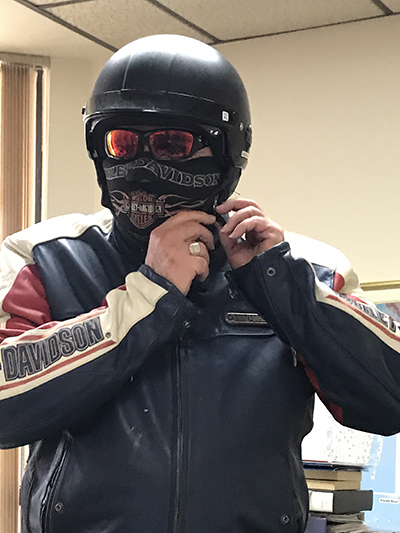 Archbishop Thomas Wenski puts on his motorcycle mask and gear. A ride once a month, outside the city, he said, helps him de-stress and "clear the cobwebs" from his mind.