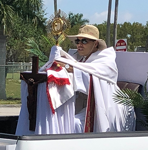 El P. Yamil Miranda, de la iglesia All Saints, portó Recientemente la hostia consagrada por las calles de Sunrise, con un feligrés que trasmitía la procesión mediante un iPhone.