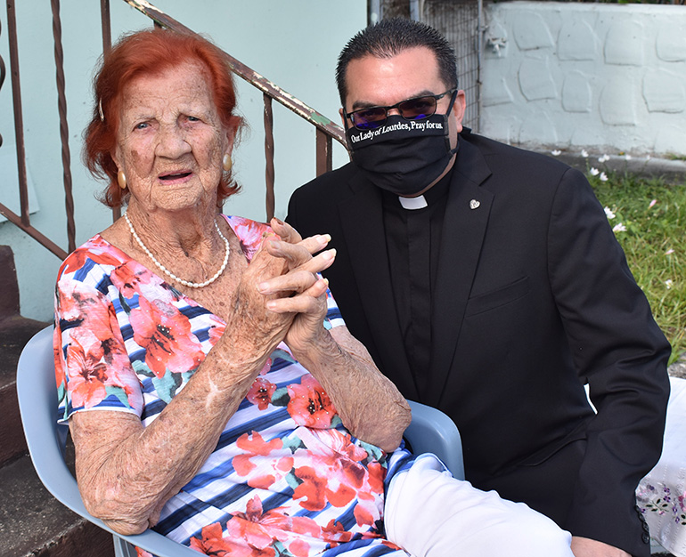 Father Javier Barreto of Little Flower Church in Hollywood poses with Stella Waite during her 105th birthday party.