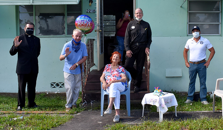 Well-wishers wave during Stella Waite's 105th birthday party in Hollywood. At left is Father Javier Barreto of Little Flower Church, where she has been a member since the 1940s. Second from right is Peter Pazer, a lay minister at the church.