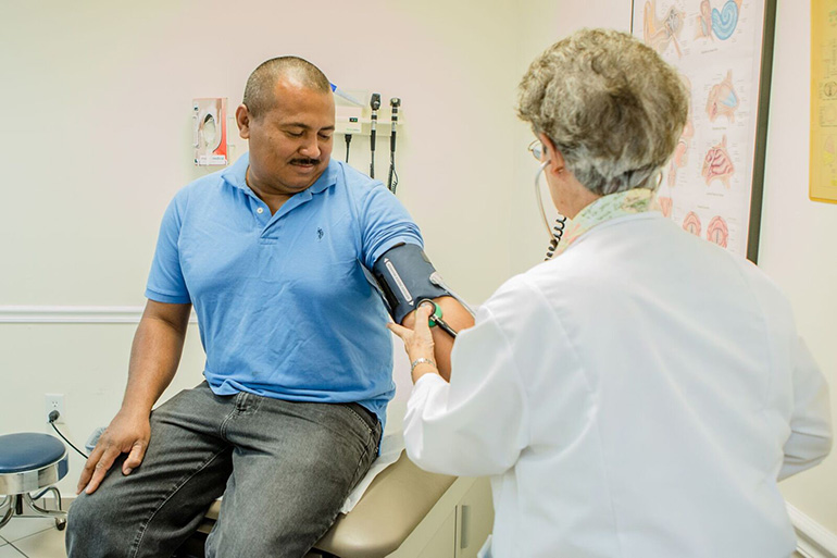 One of the volunteer doctors at the St. John Bosco Clinic takes a patient's vital signs in this file photo. The clinic, sponsored by the Sisters of St. Joseph of St. Augustine, is a member of the Florida Association of Free and Charitable Clinics.