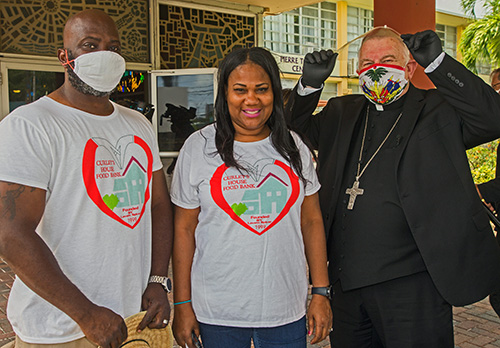 Arthur and Laverne Spicer, founders of Curley's House food bank, pose for a photo with Archbishop Thomas Wenski. Curley's House sponsored the food distribution May 23, 2020 where the archbishop helped Father Reginald Jean-Mary, Notre Dame d'Haiti pastor hand out food.