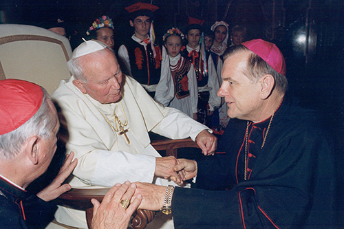 El arzobispo Thomas Wenski habla con el Papa Juan Pablo II durante una visita que hizo a Roma con un grupo de peregrinos en la década de los 2000.