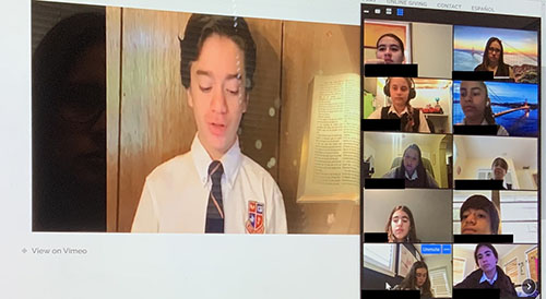 Un estudiante de la Escuela St. Hugh lee las lecturas del día, mientras otros estudiantes miran y escuchan durante la misa seminal, por internet de la escuela. Aunque las escuelas permanecieron cerradas por el coronavirus, los estudiantes y profesores de St. Hugh se reunieron todos los viernes para su misa escolar semanal.