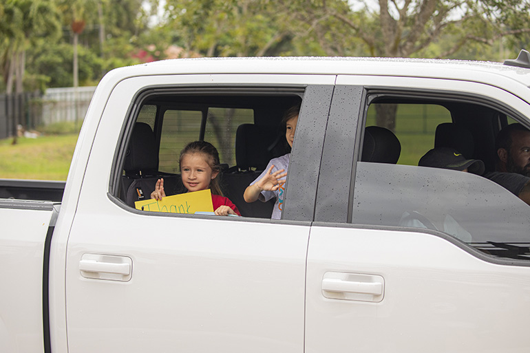 Blessed Trinity School students Valentina Hernandez, left, and Evelyn Veiguela participate in the "Cougar Care Caravan," May 14, 2020. Parents took their children on a "drive-by" to the school where they were given bags filled with surprises.