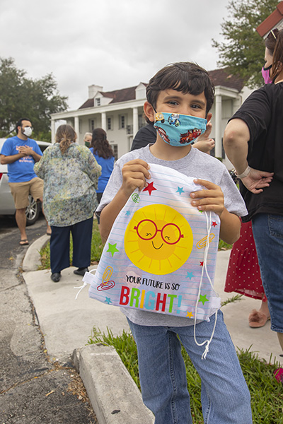 Blessed Trinity School kindergarten student Lucas Cambert holds one of the gift bags handed out to students at the "Cougar Care Caravan," May 14, 2020. Parents took their children on a "drive-by" to the school where they were given bags filled with surprises.