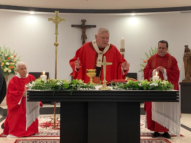 Archbishop Thomas Wenski celebrates Mass in the chapel of Mother of Christ Church in Miami, where he consecrated the new altar during the vigil Mass May 30, 2020. At right is Mother of Christ's administrator, Father Jorge Carvajal-Nino.