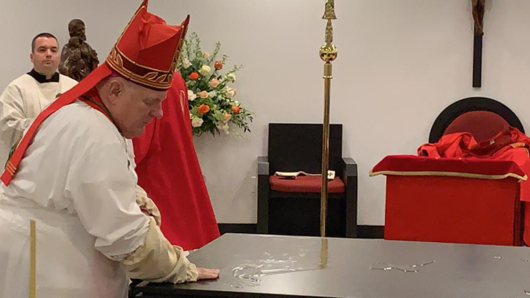 El Arzobispo Thomas Wenski usa aceite para ungir el nuevo altar de la capilla de la iglesia Mother of Christ en Miami, durante la vigilia de Pentecostés, el 30 de mayo de 2020.