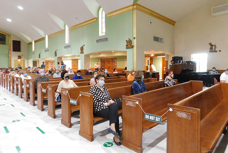 St. Joseph Parish, Miami Beach, put signs on the floor and on the pews to let parishioners konw where they could sit, in keeping with the required social distancing.
