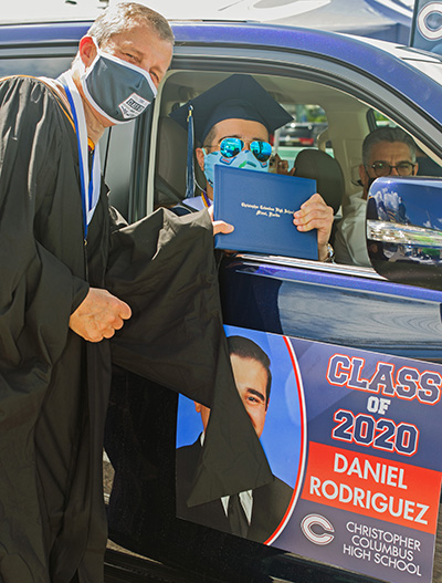 Christopher Columbus High School's president, Thomas Kruczek, gives a diploma to graduate Daniel Rodriguez. Because of the pandemic, the Miami school celebrated its graduation at the Homestead Miami Speedway June 20, 2020.