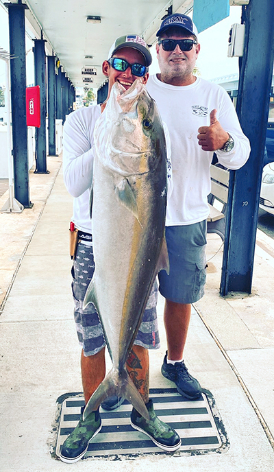 A.J. Staggs, a crew member of the Key West-based Linda D Sportsfishing charter boat, left, displays a fish he caught recently as part of the St. Peter's Fleet partnership with the SOS Foundation and local charter boats. With him, at rear, is Captain Billy Wickers III, business owner.