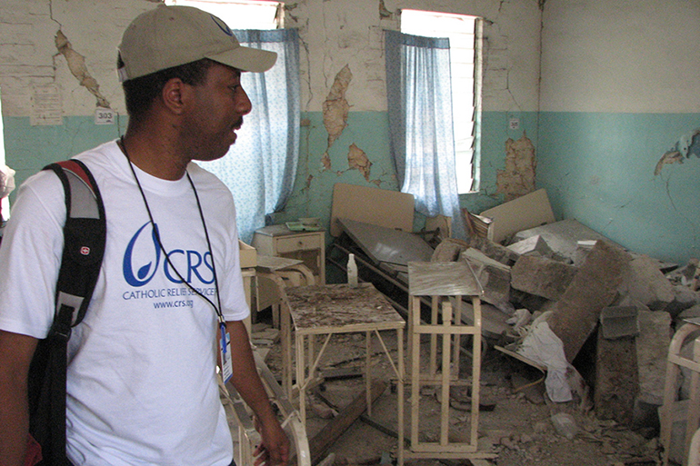 A Catholic Relief Services worker looks at the remains of a hospital in Haiti in this file photo from April 2018. Relief agencies are worried that the country's frail health system won't be able to cope with an upsurge in COVID-19 cases. There is also concern that the number of cases and deaths being reported in the country do not accurately reflect reality.