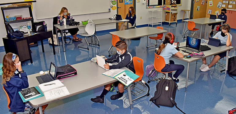 Los estudiantes de tercero a séptimo grado estudian en el aula de Patricia Johnston, en la Escuela St. Bonaventure, el primer día de clases en su sala de estudio para hijos de trabajadores esenciales, el 24 de agosto de 2020.