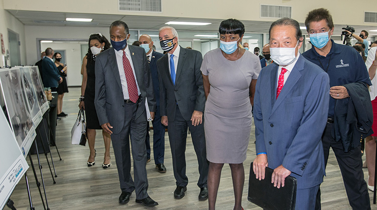 Looking at renderings of the new buildings and renovations at the Three Round Towers low-income senior housing in Allapattah, from left: Ben Carson, U.S. Secretary of Housing and Urban Development; Miami-Dade County Mayor Carlos Gimenez; Miami-Dade County Commission Chairwoman Audrey Edmondson; Michael Liu, director of the Miami-Dade Public Housing and Community Development Department; and Peter Routsis-Arroyo, CEO of Catholic Charities. Carson visited Catholic Charities' Malcolm Ross Senior Center, located in the Three Round Towers complex, Aug. 13, 2020.