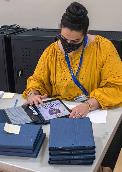 St. Mary Cathedral School's second grade teacher, Cristina Gomez-Torres, sets up iPads for students as COVID-19 induced virtual school opened, Aug. 19, 2020.